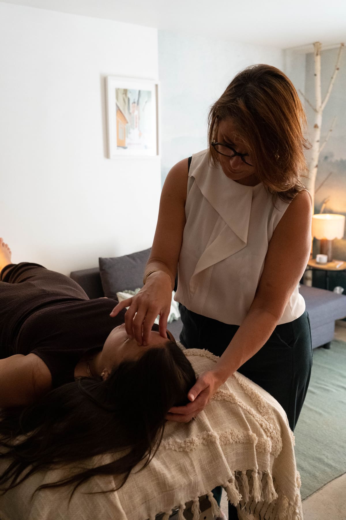Kristel Thorand, mains posées sur la tête d'une patiente allongée